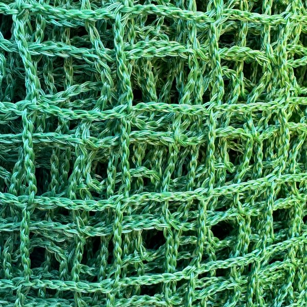 Närbild av ett hållbart och lätt polyetennät. Perfekt för säkring av last, släpvagnar och avspärrningar